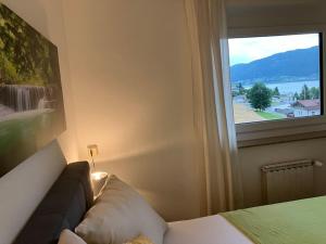 a bedroom with a bed and a window with a view at Ferienhaus Julia - Ossiacher See in Sattendorf