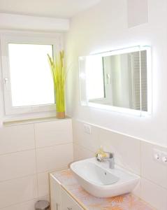 a white bathroom with a sink and a mirror at Ferienhaus Julia - Ossiacher See in Sattendorf