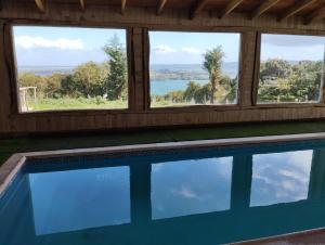 una piscina con ventanas y vistas al lago en Azul y Verde B&B en Ancud