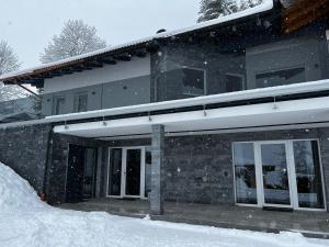 een huis bedekt met sneeuw ervoor bij Mountain Home Alpendorf in Plankenau