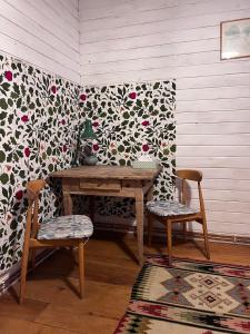 une table et deux chaises dans une pièce avec un mur dans l'établissement Flat 56, à Stara Kamienica