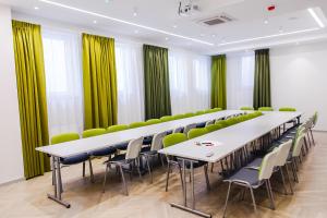 a conference room with white tables and green chairs at Hotel Willa Odkrywców in Szklarska Poręba