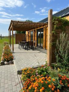 a patio with a table and chairs and flowers at Słoneczny Horyzont in Zastań