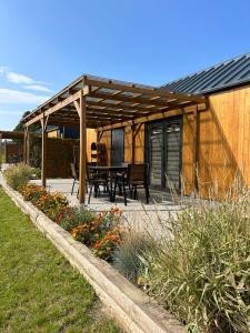 a wooden pavilion with a picnic table in a garden at Słoneczny Horyzont in Zastań