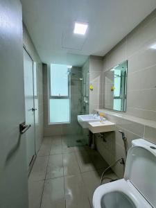 La salle de bains est pourvue d'un lavabo, de toilettes et d'un miroir. dans l'établissement Hstay Sutera Avenue 2Bedroom by Aida, à Kota Kinabalu
