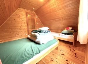 a room with two beds in a wooden cabin at Domki pod Kiczerą w Baligrodzie, Bieszczady in Baligród