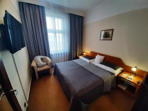 a hotel room with a bed and a chair at Hotel BAST Wellness & SPA in Inowrocław +89 photos