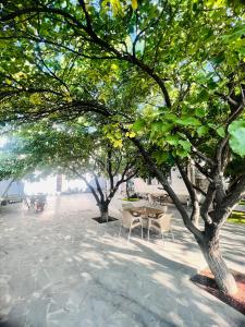 een tafel en stoelen onder de bomen op een stoep bij MarNar Hotel in Jerevan