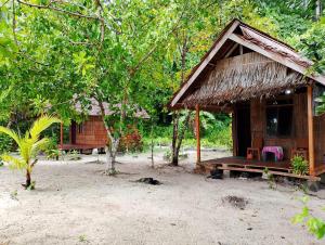 une petite cabane avec un banc devant elle dans l'établissement Raja Ampat Diva homestay, à Waisai