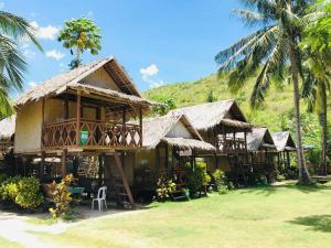 a resort with a large building with palm trees at Ocam Ocam Casadyan Inn in New Busuanga