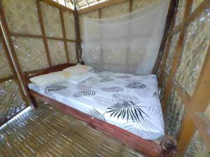a small bed in a yurt with a mosquito net at Ocam Ocam Casadyan Inn in New Busuanga