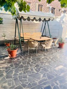 - une table de pique-nique et des chaises sous un auvent sur une terrasse dans l'établissement MarNar Hotel, à Erevan