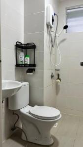 古晉的住宿－Hana Guesthouse Metrocity (Nearby City Centre)，白色的浴室设有卫生间和水槽。