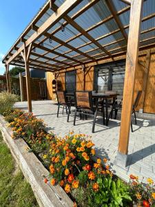 a patio with a pergola and a table and flowers at Słoneczny Horyzont in Zastań