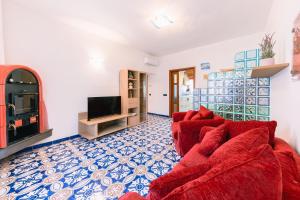 a living room with a red couch and a tv at Casa Vacanze La Trinità in Ravello