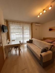 a bedroom with a couch and a table and a window at Merano Panoramablick ruhig gelegen in Merano