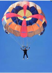 un hombre volando por el aire con un paracaídas en Desert Safari Jaisalmer en Sām