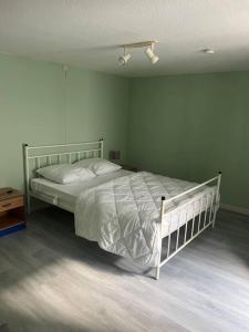 ein Schlafzimmer mit einem weißen Bett in einem Zimmer in der Unterkunft Gîte le Carassin in Bouillon
