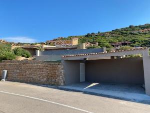 a house with a retaining wall and a stone wall at Charlie Home - Heart of Sardinia in Costa Paradiso