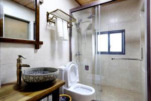 uma casa de banho com um lavatório, um WC e um chuveiro em Millennium Boutique Hotel em Zhangjiajie