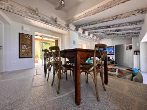 a dining room with a wooden table and chairs at Charlie Home - Heart of Sardinia in Costa Paradiso