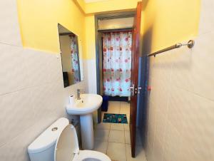 a small bathroom with a toilet and a sink at The Little Haven - Ample Parking, Views & Netflix in Kikuyu