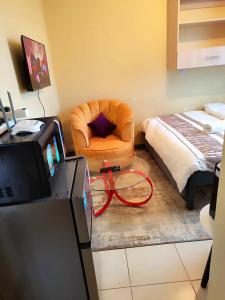 a living room with a chair and a bed at The Little Haven - Ample Parking, Views & Netflix in Kikuyu