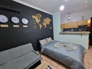 a bedroom with two beds and clocks on the wall at Amazing studio Φωλιά in Xanthi - myHomee in Xanthi