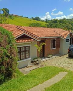 a small house with a red roof at Chácara Sonho Meu in Pinhalzinho
