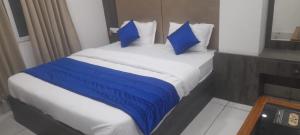 uma cama com almofadas azuis num quarto de hotel em hotel adhunik palace em Keonjhargarh
