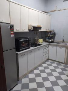 a kitchen with white cabinets and a checkered floor at EMPRESS SIGNATURE in Kuala Lumpur