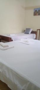 a group of three white beds in a room at 4ty two Homestay Galle in Galle