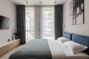 Schlafzimmer mit einem großen Bett mit blauem Kopfteil in der Unterkunft Old City Apartments in Lwiw