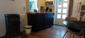 a kitchen with a counter with a sink and a table at Authentiek vakantiehuisje in Terneuzen