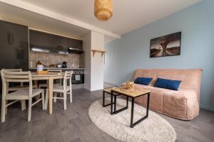 a living room and kitchen with a couch and a table at Escapade à 10 min d’ETRETAT in Criquetot-lʼEsneval +10 photos
