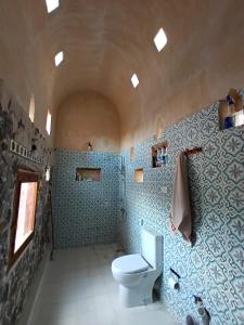 錫瓦的住宿－مراقي سيوة Maraqi Siwa，浴室设有白色卫生间和蓝色瓷砖。