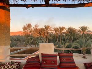a room with a couch with palm trees in the background at مراقي سيوة Maraqi Siwa in Siwa