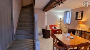 ein Wohnzimmer mit einem Esstisch und einer Treppe in der Unterkunft La Hulottière Chouette Gîte 