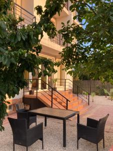 a picnic table and chairs in front of a building at Vila Libra Costinesti in Costinesti