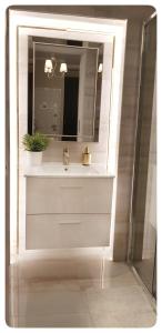 bagno con lavandino e specchio di Elania Residence a Târgu Jiu