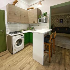 een keuken met groene kasten en een wasmachine bij Edem Apartments in Lviv in Lviv