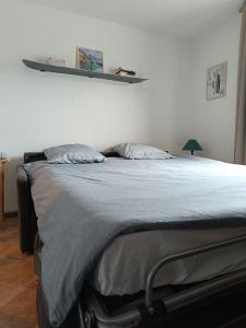 Un pat sau paturi într-o cameră la Charmant studio avec terrasse