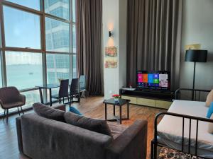 uma sala de estar com um sofá e uma televisão de ecrã plano em Fantastic Seaview Loft 2R2B 9Pax #Maritime em Jelutong