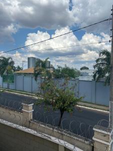 a fence with a tree in the middle of a street at Apartamento inteiro acomoda 5 pessoas in Uberlândia