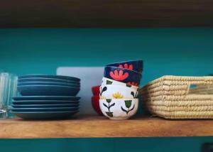 a table with plates and a vase on a shelf at Casita Vinita in Nosara