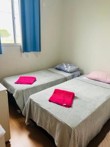 two beds in a room with pink towels on them at Apartamento inteiro acomoda 5 pessoas in Uberlândia
