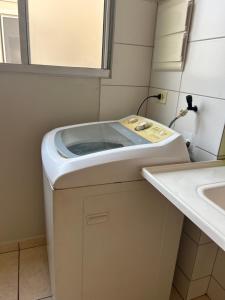 a washing machine in a bathroom next to a sink at Apartamento inteiro acomoda 5 pessoas in Uberlândia