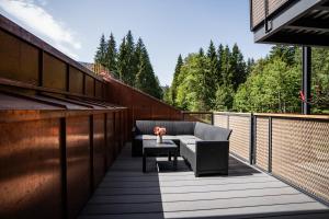 a patio with a couch and a table on a balcony at Hochwertige Ferienwohnung Hochsitz in Saulgrub