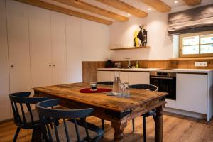 a kitchen with a wooden table and chairs at Hochwertige Ferienwohnung Hochsitz in Saulgrub