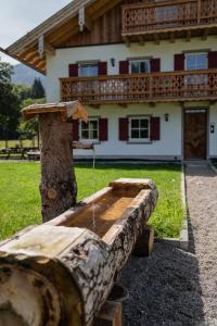 a tree stump with a water fountain in front of a house at Hochwertige Ferienwohnung Hochsitz in Saulgrub